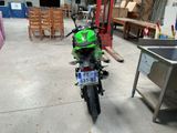 a green motorcycle that is parked in a garage