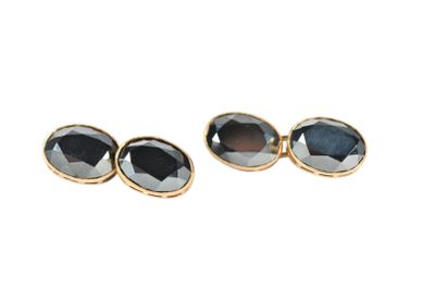 a pair of black and gold earrings on a white background
