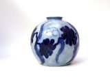 a blue and white vase sitting on a white surface
