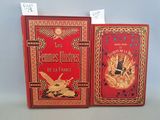 deux livres rouges ornés de dorures, posés l'un à côté de l'autre