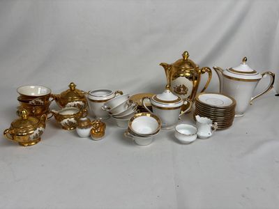 beaucoup de vaisselle en porcelaine dorée et blanche sur une table