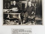 an old black and white photo of two men sitting at a desk