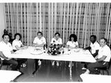 un groupe de personnes assises à une table devant des assiettes de nourriture