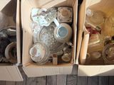 deux boîtes contenant divers objets, posées sur un plancher en bois