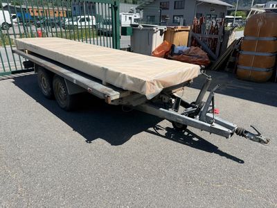 une photo d'un bateau sur une remorque dans un parking