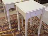 pair of white end tables on a rug in a living room