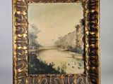 une peinture à l'huile représentant un paysage fluvial, dans un cadre doré, posée sur un chevalet en bois
