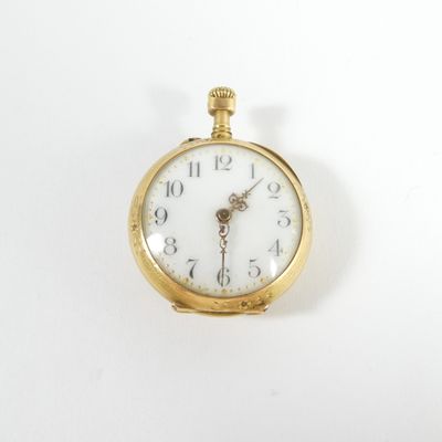 une montre de poche en or avec un cadran blanc sur une surface blanche