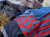 a pile of clothes sitting on top of a pile of luggage