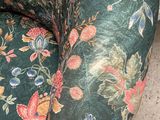 a cat that is sitting on a floral couch