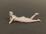 a figurine of a woman laying on the ground