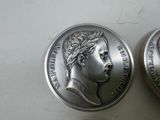 two silver coins sitting next to each other on a table