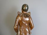 bronze statue of a man with a bow on his head