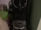une cafetière noire posée sur un plan de travail, à côté d'une bouteille de lait