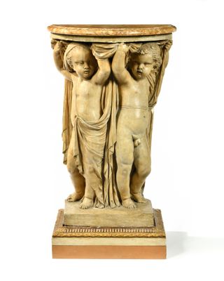 une statue représentant deux enfants, posée sur un socle surmonté d'un plateau en marbre