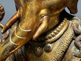 a gold statue of an elephant holding a baby elephant