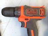a black and decker drill that is laying on the floor