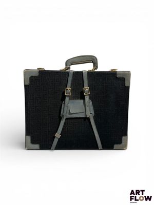 une image représentant une valise noire sur fond blanc