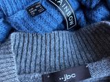 two pairs of blue and grey sweaters with a tag on them