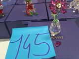 five glass figurines of angels on a purple box