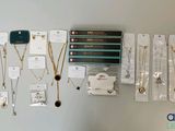 many necklaces hanging on the wall with tags attached to them
