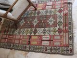 a rug on the floor with a chair in the corner