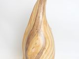 a wooden vase that is sitting on a white surface