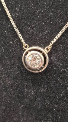 un gros plan d'un collier orné d'un diamant sur un fond noir