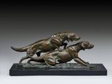 deux sculptures en bronze représentant des chiens en pleine course, posées sur un socle en marbre