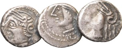 trois pièces de monnaie romaines anciennes, dont l'une représente une femme et l'autre un homme