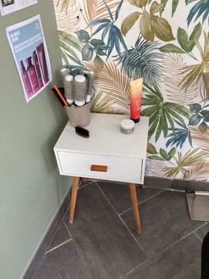 a small table with a candle on it in the corner of a room