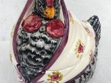 a small ceramic chicken with a red bow on it ' s head
