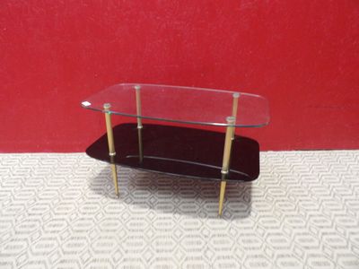 une table en verre sur laquelle est posé un skateboard