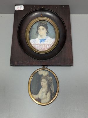 deux portraits encadrés représentant une femme et un homme, accrochés au mur