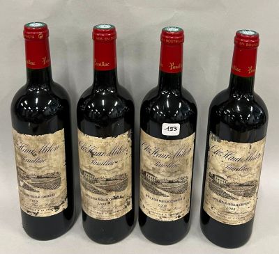 trois bouteilles de vin rouge sont alignées sur une table
