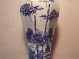 un vase bleu et blanc posé sur une table