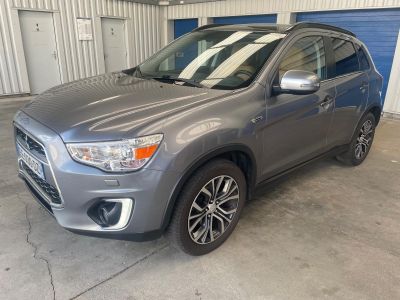 un SUV gris garé dans un garage dont la porte est bleue