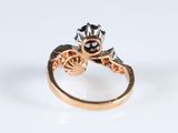a close up of a ring with a red stone in it