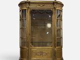 une vitrine ancienne dotée d'une porte vitrée et de garnitures dorées