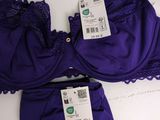 two purple bras with tags on them on a white surface