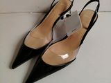 une paire de chaussures noires à talons hauts posée sur un sol blanc