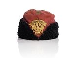un chapeau rouge et noir orné d'un emblème doré