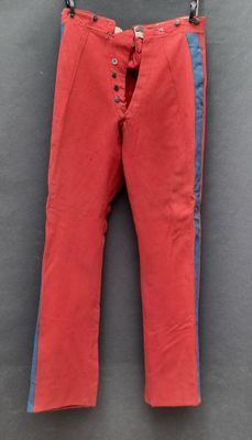 un pantalon rouge suspendu à une corde à linge
