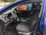 the interior of a blue car with black seats and steering controls