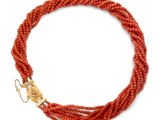 un bracelet en perles orange avec un fermoir doré