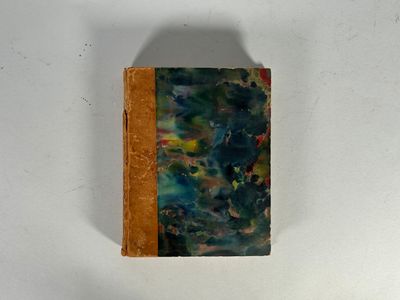 tableau accroché au mur d'une pièce aux murs blancs, avec un livre marron