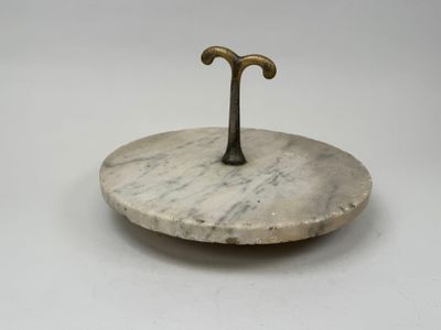une plaque en marbre blanc munie d'une poignée en laiton