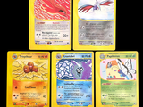 Quatre cartes Pokémon différentes sont représentées sur un fond noir