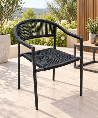 une chaise noire posée sur une terrasse, avec une table et des plantes en pot