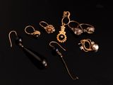 un ensemble de boucles d'oreilles dorées et noires posées sur un fond noir